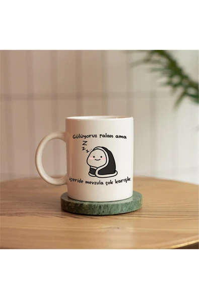 ALPŞAN TİCARET  GÜLÜYORUZ FALAN AMA İÇERİDE MEVZULA ÇOK KARIŞIK YAZILI HEDİYELİK BASKILI KUPA ürün görseli